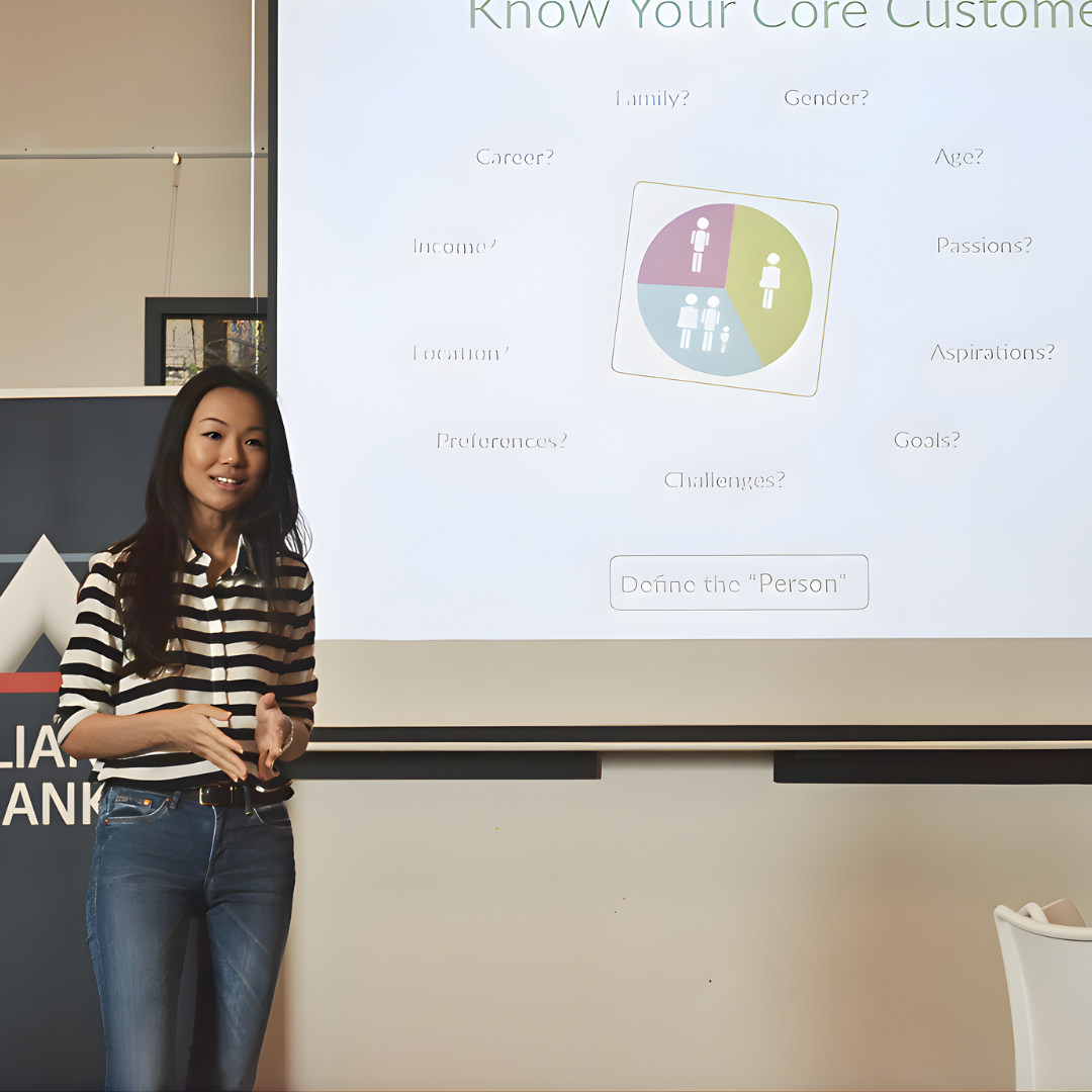 Therine Goh facilitating a training session in front of a presentation screen